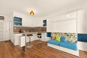 a living room with a blue couch in a kitchen at Didi`s Stylish Studio - Seaview & Pool Backyard in Varna City