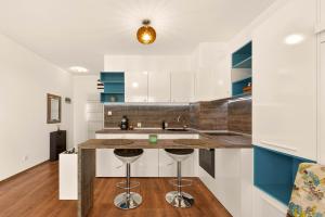 a kitchen with blue and white cabinets and a counter with stools at Didi`s Stylish Studio - Seaview & Pool Backyard in Varna City +18 photos
