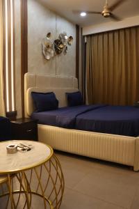 een slaapkamer met een groot bed en een tafel bij High Sky inn in Noida