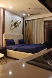 een slaapkamer met een bed met blauwe kussens bij High Sky inn in Noida