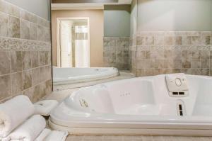 Un baño con bañera, lavabo y espejo. en Rodeway Inn Allentown South, en Allentown 42 fotos más