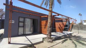 奥兰治蒙德Unit 7 Dinas Accommodation Oranjemund的前面有一棵树的小房子