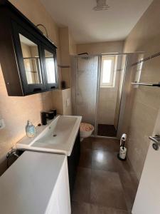 ein Badezimmer mit einem weißen Waschbecken und einer Dusche in der Unterkunft Ostwind in Graal-Müritz + 3 Fotos