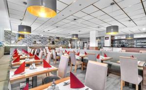 フランチシュコヴィ・ラーズニェにあるLázeňský hotel Pyramidaの赤い旗が掲げられたテーブルと椅子のあるレストラン