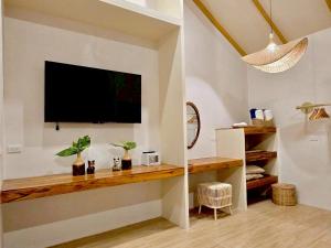 チャウエンにあるUbox samui hostel & Bungalow - Chaweng beachの壁にテレビが掛かっているリビングルーム