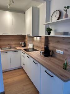 a kitchen with white cabinets and a clock on the wall at Ferienwohnung Lüttje Mööv 2 an der Nordsee in Wangerland