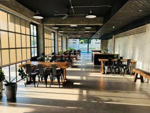 Un restaurante con mesas y sillas de madera y ventanas. en Sena Hotel Langkawi, en Kampung Padang Masirat