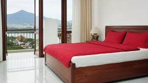 Un dormitorio con una cama con almohadas rojas y una ventana. en Trang an Apartment, en Kon Rung (1) 12 fotos más