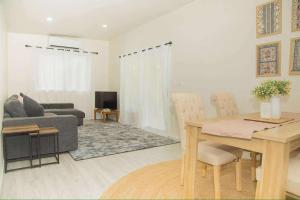 un soggiorno con un tavolo e un divano di 2 Bedroom House - Villa Teremoana a Ngatangiia