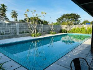 Una piscina con agua azul en un patio. en Sena Hotel Langkawi, en Kampung Padang Masirat