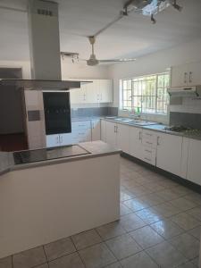 eine große weiße Küche mit weißen Schränken und Geräten in der Unterkunft Bnb, Gaborone Botswana in Gaborone