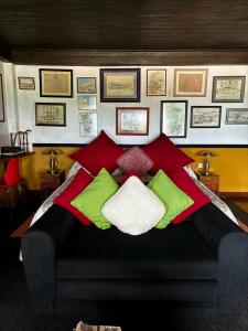 a bedroom with a bed with red and green pillows at Rugby House Kandy in Kandy