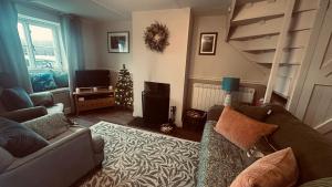 a living room with a couch and a christmas tree at 18th Century Thatched Cottage Parking & Garden in Beaminster