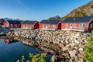レクネスにあるStatles Rorbu- og Konferansesenter ASの岩壁の隣に並ぶ赤い家々