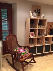 a rocking chair in a room with a book shelf at Apartamento Merceria - Tarragona in Tarragona