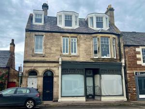 un coche aparcado frente a una casa de ladrillo en Overton - Elie, en Elie