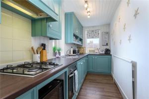 cocina con armarios azules y fogones en Overton - Elie, en Elie