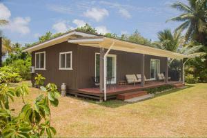 una piccola casa marrone con un portico e delle sedie di 2 Bedroom House - Villa Teremoana a Ngatangiia