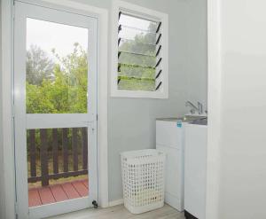 una cucina con porta che conduce a un balcone di 2 Bedroom House - Villa Teremoana a Ngatangiia Altre 28 foto