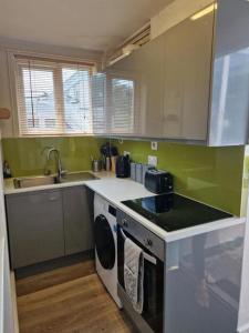 une cuisine avec un évier et une cuisinière four supérieur dans l'établissement NEWLY Refurbed - Large Studio Apt With Private Parking, à Exeter