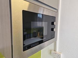 une télévision est fixée à un mur dans l'établissement NEWLY Refurbed - Large Studio Apt With Private Parking, à Exeter