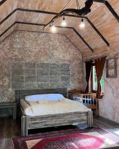 a bedroom with a bed in a stone wall at Dili Heaven in Dilijan