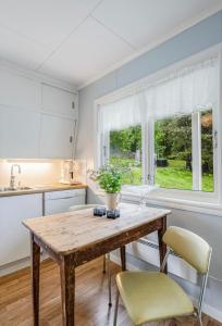 eine Küche mit einem Holztisch und Stühlen sowie einem Fenster in der Unterkunft A Cozy Nordic Home in Ålset + 25 Fotos