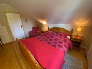 ein Schlafzimmer mit einem großen Bett mit einer roten Bettdecke in der Unterkunft A Cozy Nordic Home in Ålset