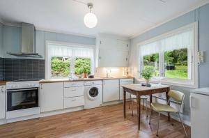 a kitchen with white appliances and a table and chairs at A Cozy Nordic Home in Ålset