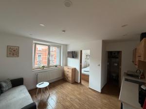 ein Wohnzimmer mit einer Couch und einem Fenster in der Unterkunft ApartmentsByMatyrafa-XIV in Tarnowitz