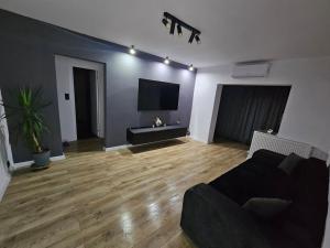 un soggiorno con divano e TV a schermo piatto di Promenada mall side a Craiova