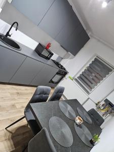 una cucina con tavolo, sedie e fornelli di Promenada mall side a Craiova