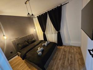 una camera da letto con un letto con due asciugamani sopra di Promenada mall side a Craiova