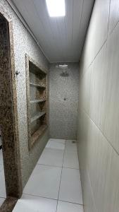 VERÃO ROOTs في ايليوس: غرفة بها دش واسع وأرضية من البلاط