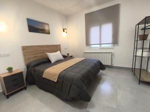 una camera da letto con un letto grande con testiera in legno di Alojamiento Rural El Lentisco  Altre 14 foto