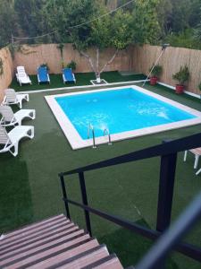 una piscina in un cortile con sedie e recinzione di Alojamiento Rural El Lentisco 