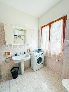 ein Badezimmer mit Waschmaschine und Waschbecken in der Unterkunft Maria Vittoria in Campese