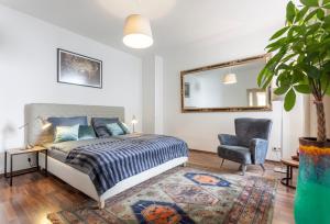 1 dormitorio con cama, silla y espejo en GreatStay Apartment - Rheinsbergerstr., en Berlín