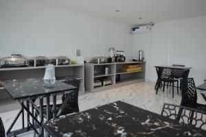 a kitchen with tables and chairs in a room at Lux Living Hotel in Bangalore