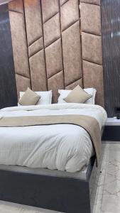 a bedroom with a large bed with a padded wall at Hotel Rashmi Grand in Khagaria