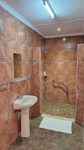un baño con lavabo y ducha en Mariental Hotel Cc, en Mariental 24 fotos más