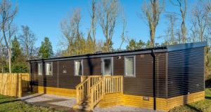 a small wooden cabin with a wooden deck at Best Western Plus Kenwick Park Hotel in Louth