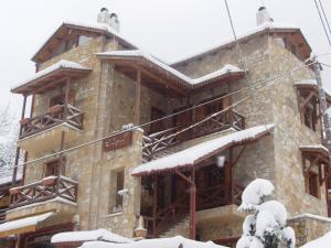 budynek pokryty śniegiem w obiekcie Enthymio Suites w mieście Synikia Mesi Trikalon