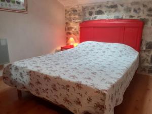ein Schlafzimmer mit einem Bett mit rotem Kopfteil in der Unterkunft Gîte de charme la Fenière in Joyeuse