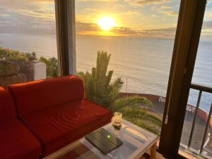 een woonkamer met een bank en uitzicht op de oceaan bij Esperanza in Tacoronte +7 foto's