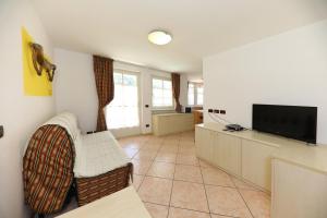a living room with a flat screen tv and chairs at Villa Marta in Mazzin