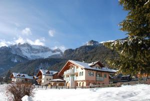 a house in the snow with mountains in the background at Villa Marta in Mazzin