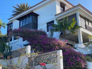 een wit huis met paarse bloemen ervoor bij Esperanza in Tacoronte