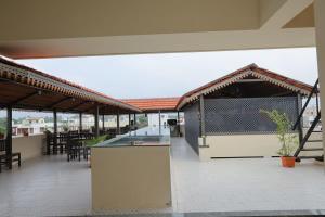 an outdoor patio with a bar and tables and chairs at Aranya in Thanjāvūr