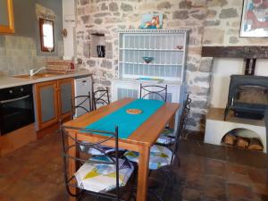eine Küche mit Holztisch und Herd in der Unterkunft Gîte de charme la Fenière in Joyeuse